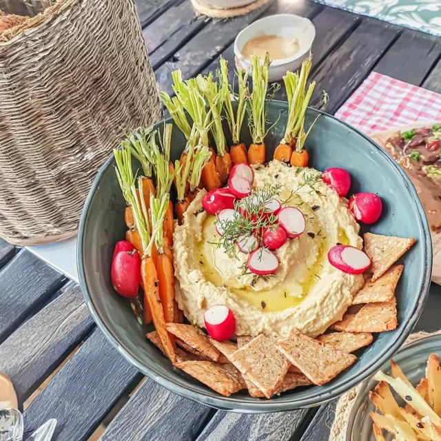 Antipasti-Platte mit Hummus, jungen Karotten und Zuckerschoten