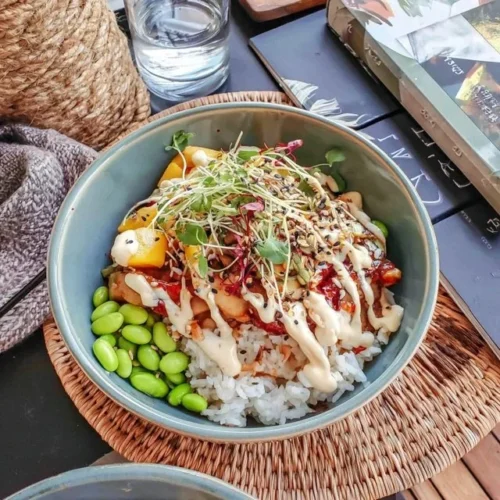 Buddha-Bowl mit Mango, Edamame und Jasminreis auf einem Teller