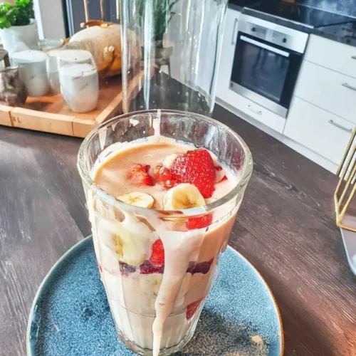 Erdbeer-Bananen-Smoothie mit Hafermilch in einem Glas auf einem Tisch