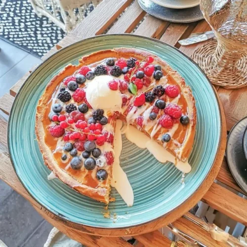 Nordische Beerentarte mit Crème fraîche auf einem Teller serviert