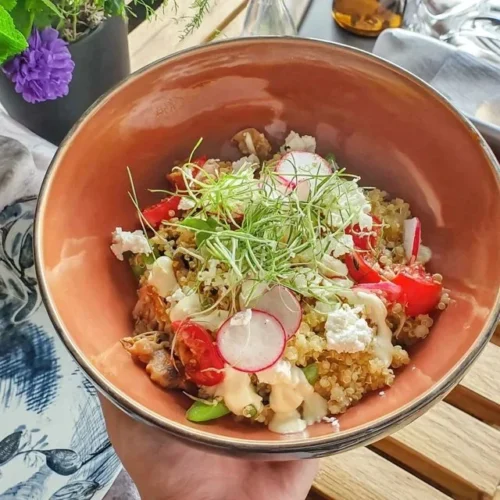 Quinoa-Bowl mit Radieschen, Erbsen und Feta auf einem Teller