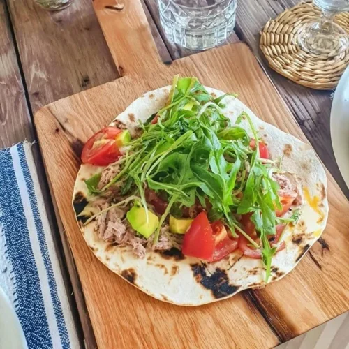 Thunfisch-Piadina mit Avocado und Tomaten auf einem Teller