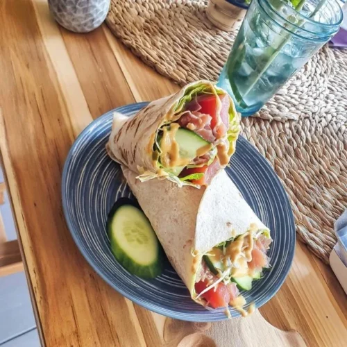 Thunfisch-Wrap mit Avocado und Gurke auf einem weißen Teller