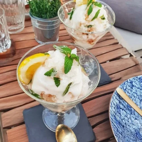 Zitronen-Granita mit frischer Minze in einem Glas serviert